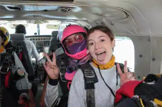 Mujer paracaidista y niña listas para saltar desde un avión especial para paracaidismo 